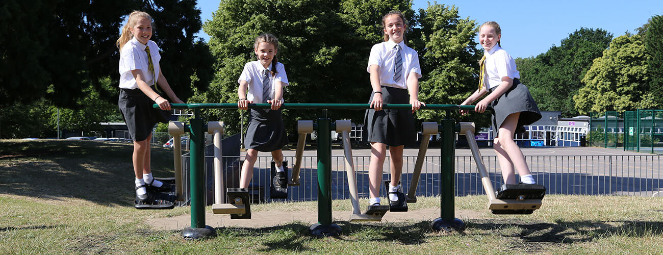 Students on outside gym equipment for schools