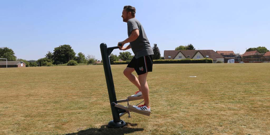 man using outdoor gym stepper