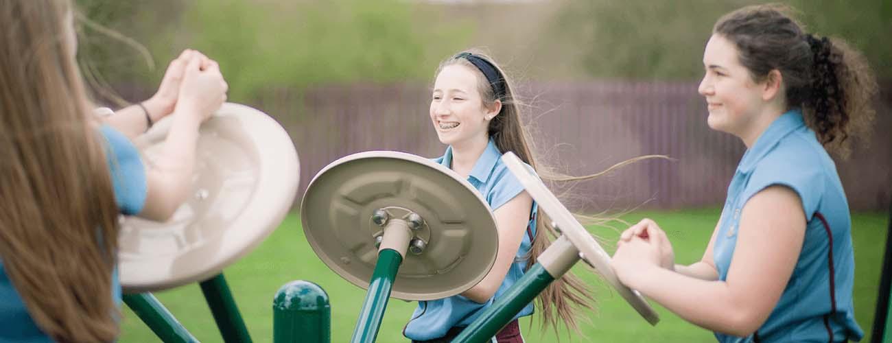 Children play on outdoor gym equipment