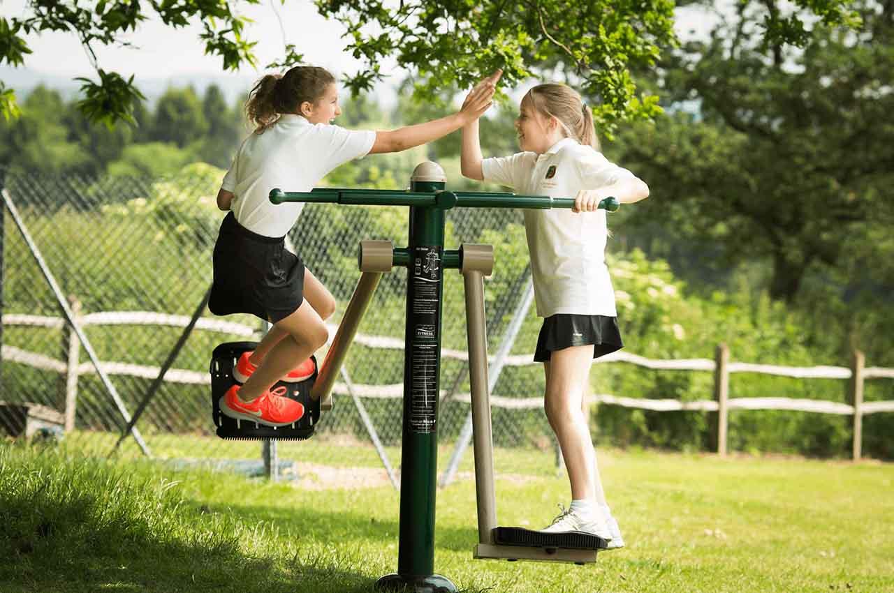 children high fiving on gym equipment