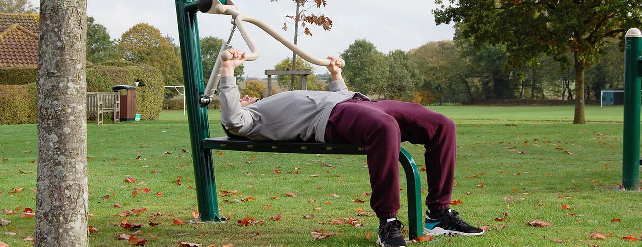 man using bench press in an outdoor gym