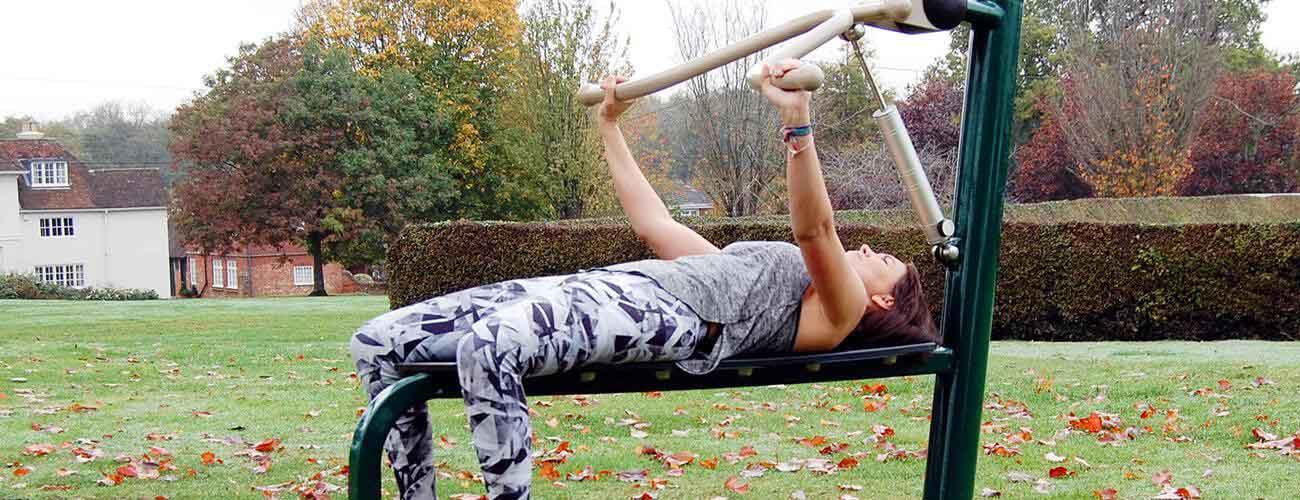 lady using bench press, fresh air fitness outdoor gym