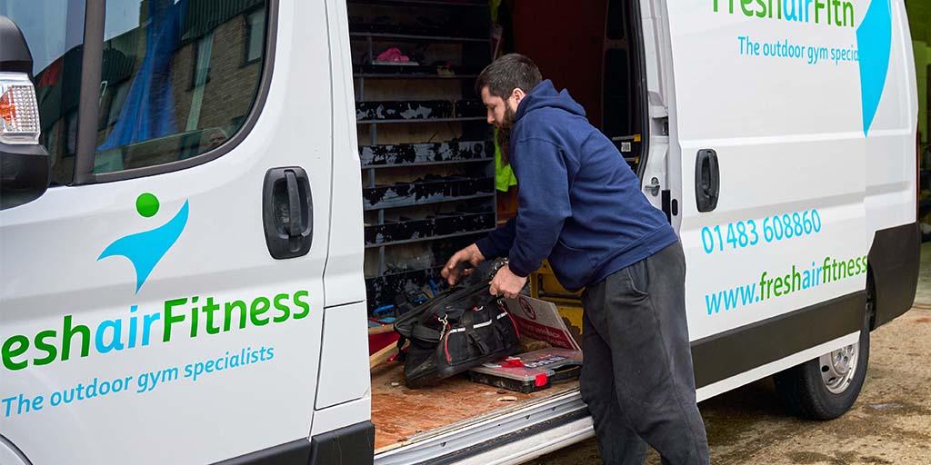 man putting tools in van