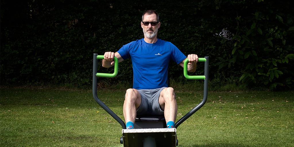 man using resistance seated row by fresh air fitness