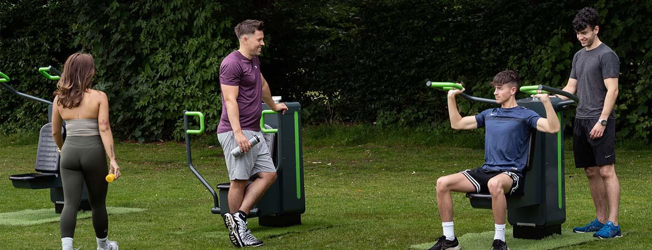 Young people socialising and workout out at outdoor gym