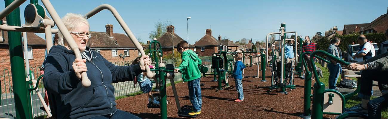 People using outdoor exercise equipment at a park