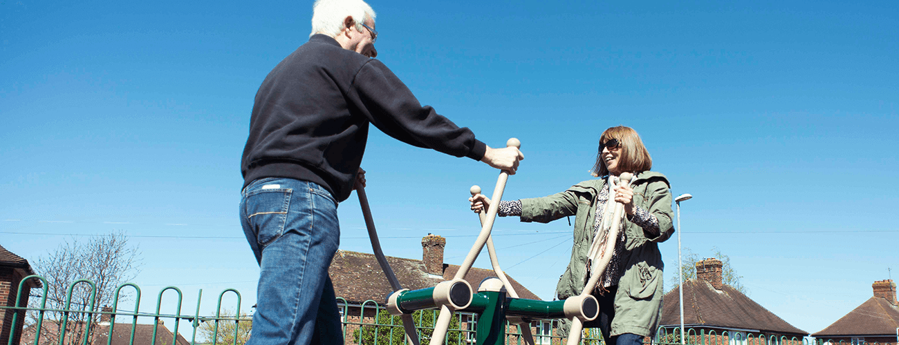 Man and lady using Green Gym equipment