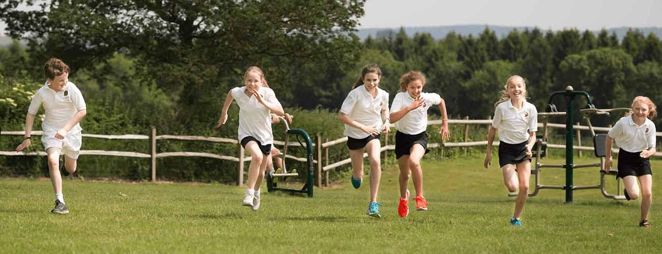 Secondary school children enjoying PE in their playing field